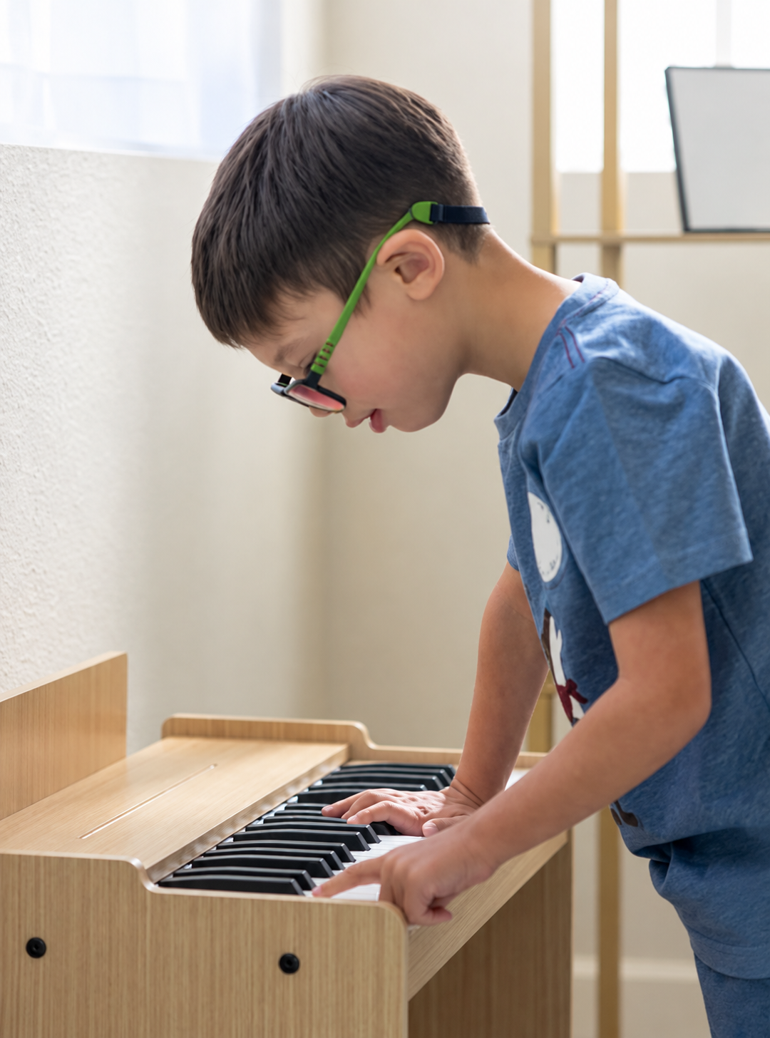 Child playing a small wooden piano