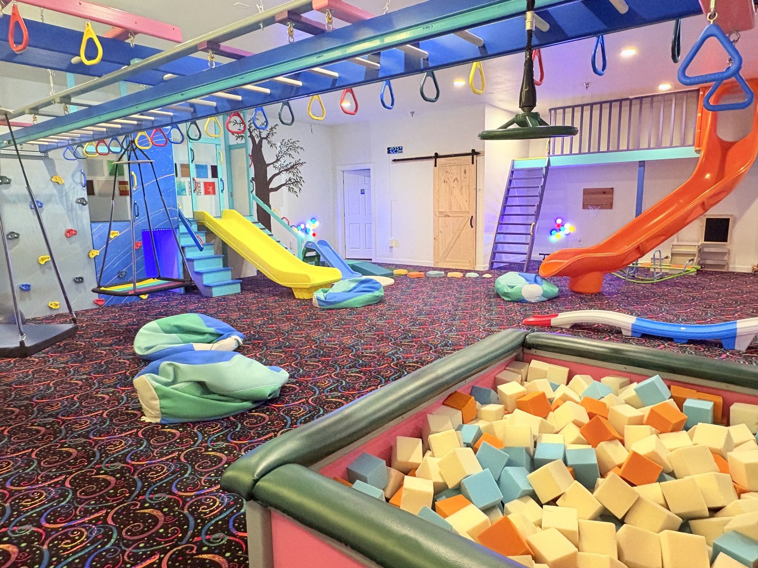 The Grove sensory-friendly play space with slides, swings, and a foam pit